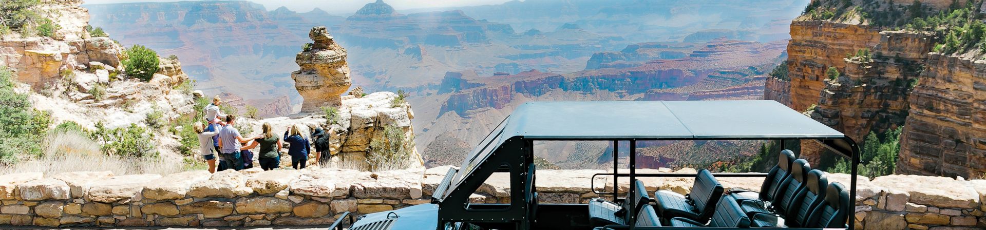 Family standing near the edge of the Grand Canyon with a Buck Wild Hummer in the foreground.