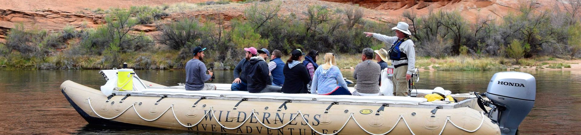 A river raft with guests powering up the Colorado River