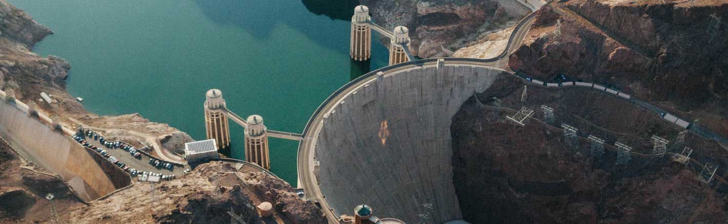 An aerial photo of the Hoover Dam with the Colorado River behind it.