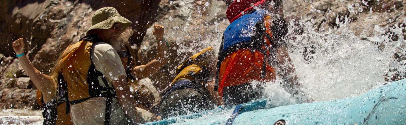 Water splashes on passengers aboard a raft.