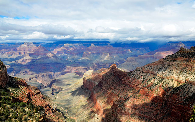 A panoramic image of the Grand Canyon and a cloudy sky.